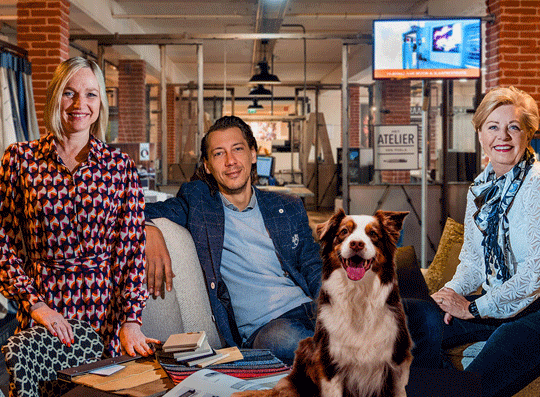 Een aantal medewerkers van Poels zitten samen met hondje Joy.